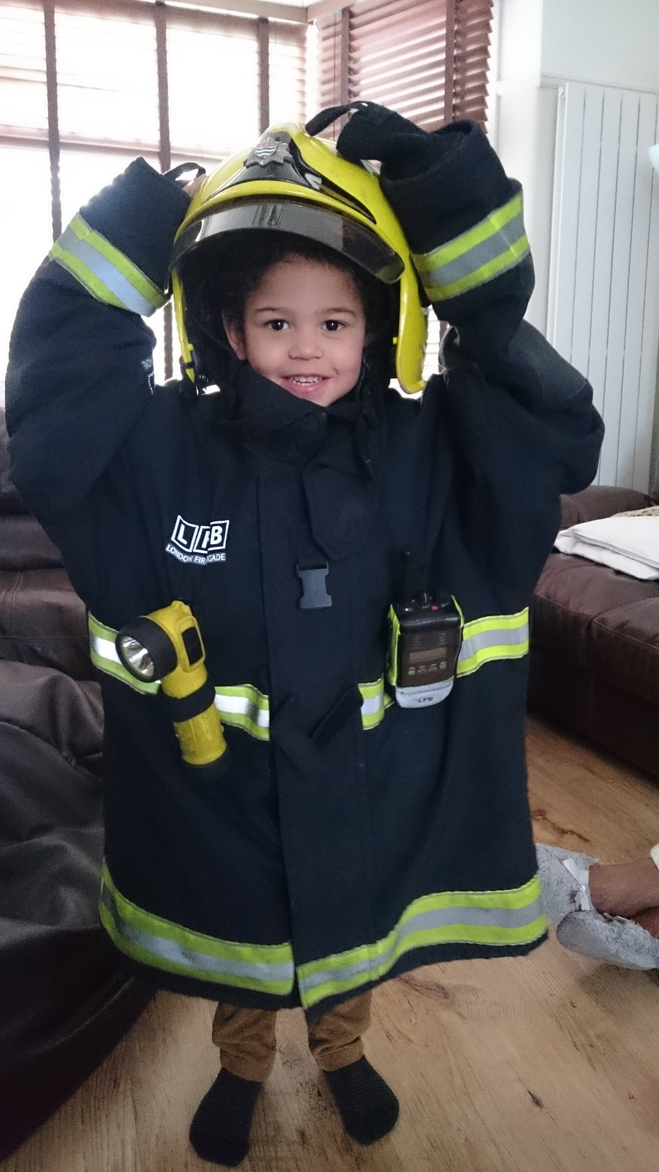 Tommy dressed up in his dad's firefighter uniform